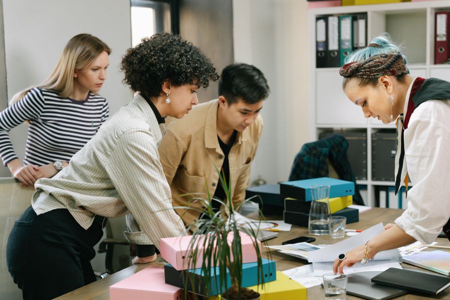 A small team collaborating around a laptop in a modern office.