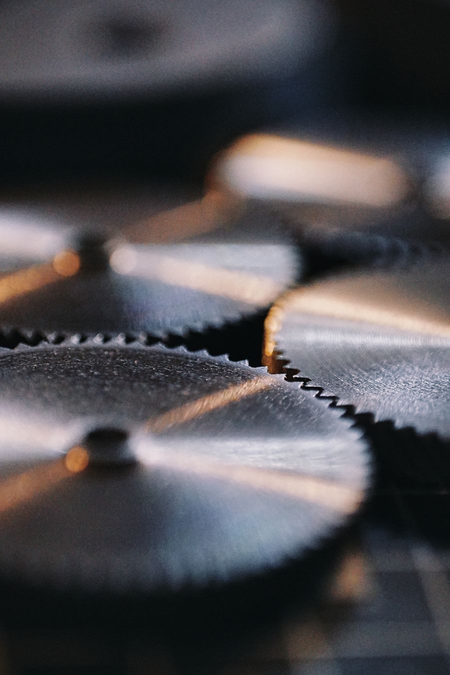 Close-up of shining metal gears meshed together inside a machine.